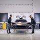 Two men fit the bumper to a $3 million hypercar.